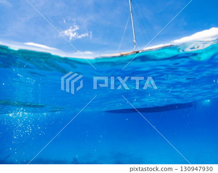 一艘雙體遊艇潛水遊輪的部分水下照片。美麗的珊瑚礁和成群的熱帶魚。沖繩縣島尻喀拉 130947930