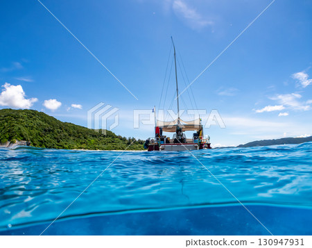 Partially submerged shot of a catamaran yacht diving cruise ship. Beautiful coral reefs and schools of tropical fish. Kera, Shimajiri District, Okinawa Prefecture 130947931