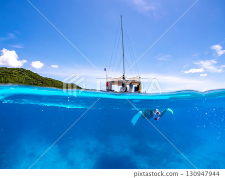 Partially submerged shot of a catamaran yacht diving cruise ship. Beautiful coral reefs and schools of tropical fish. Kera, Shimajiri District, Okinawa Prefecture Partially submerged shot of a catamaran yacht diving cruise ship. Beautiful coral reefs and schools of tropical fish. Kera, Shimajiri District, Okinawa Prefecture 130947944