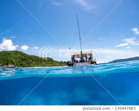 Partially submerged shot of a catamaran yacht diving cruise ship. Beautiful coral reefs and schools of tropical fish. Kera, Shimajiri District, Okinawa Prefecture 130947963