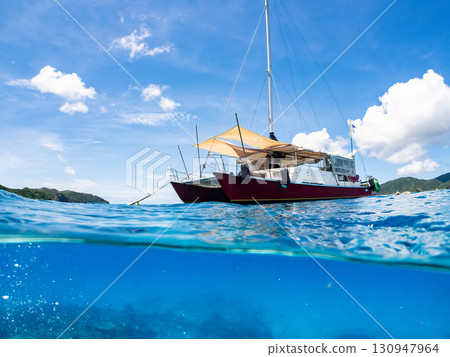 Partially submerged shot of a catamaran yacht diving cruise ship. Beautiful coral reefs and schools of tropical fish. Kera, Shimajiri District, Okinawa Prefecture Partially submerged shot of a catamaran yacht diving cruise ship. Beautiful coral reefs and schools of tropical fish. Kera, Shimajiri District, Okinawa Prefecture 130947964