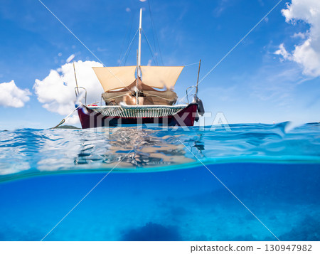 Partially submerged shot of a catamaran yacht diving cruise ship. Beautiful coral reefs and schools of tropical fish. Kera, Shimajiri District, Okinawa Prefecture 130947982