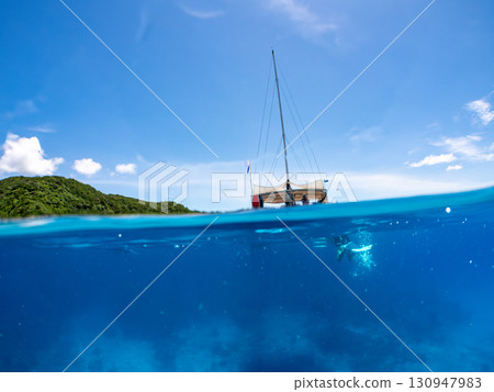 Partially submerged shot of a catamaran yacht diving cruise ship. Beautiful coral reefs and schools of tropical fish. Kera, Shimajiri District, Okinawa Prefecture 130947983