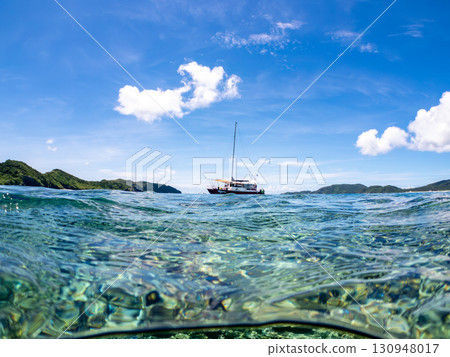 Partially submerged shot of a catamaran yacht diving cruise ship. Beautiful coral reefs and schools of tropical fish. Kera, Shimajiri District, Okinawa Prefecture 130948017