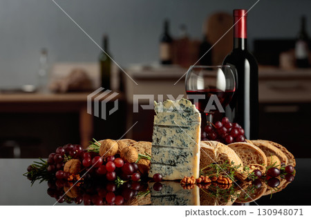 Gorgonzola cheese with ciabatta, walnuts, grapes, and red wine on a kitchen table. Gorgonzola cheese with ciabatta, walnuts, grapes, and red wine on a kitchen table. 130948071