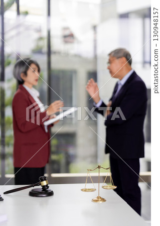 Legal professionals discussion scales of justice gavel blurred Asian adults meeting office law firm consultation courtroom concept 130948157