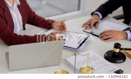 Lawyers professionals discuss legal documents during consultation in a modern law office setting symbolizing justice and advisory service 130948162