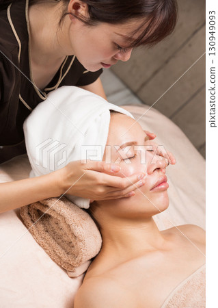 Young asian beautician doing facial massage. Young asian beautician doing facial massage. 130949093