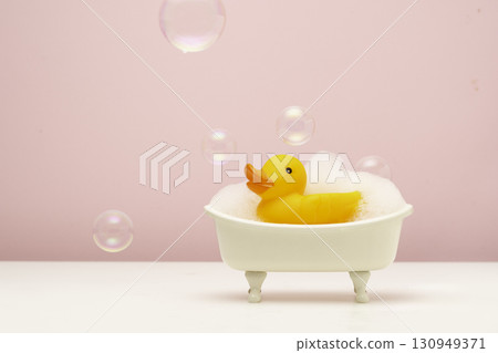 bathtub with foam and yellow rubber duck 130949371