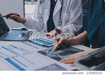 Medical team meeting analyzing blood test results in hospital laboratory. Doctors and scientists in lab coats are having a discussion about blood test result, holding test tubes and taking notes. Medical team meeting analyzing blood test results in hospital laboratory. Doctors and scientists in lab coats are having a discussion about blood test result, holding test tubes and taking notes. 130950141