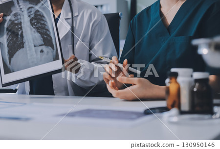 Medical team meeting analyzing blood test results in hospital laboratory. Doctors and scientists in lab coats are having a discussion about blood test result, holding test tubes and taking notes. Medical team meeting analyzing blood test results in hospital laboratory. Doctors and scientists in lab coats are having a discussion about blood test result, holding test tubes and taking notes. 130950146