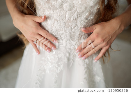 Bride wearing a stunning white wedding dress, proudly showcasing a dazzling diamond engagement commitment and symbolizing love ring, Bride wearing a stunning white wedding dress, proudly showcasing a dazzling diamond engagement commitment and symbolizing love ring, 130950256