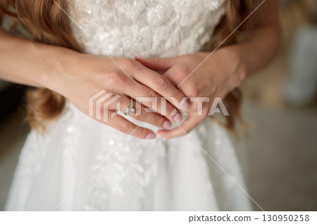Bride wearing a stunning white wedding dress, proudly showcasing a dazzling diamond engagement ring, and love commitment symbolizing Bride wearing a stunning white wedding dress, proudly showcasing a dazzling diamond engagement ring, and love commitment symbolizing 130950258