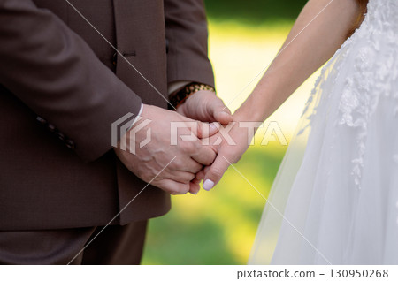Couple holding hands during a wedding ceremony, embodying love and commitment while celebrating their unity and together future shared 130950268