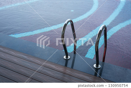 Grab bar ladder in swimming pool Grab bar ladder in swimming pool 130950754