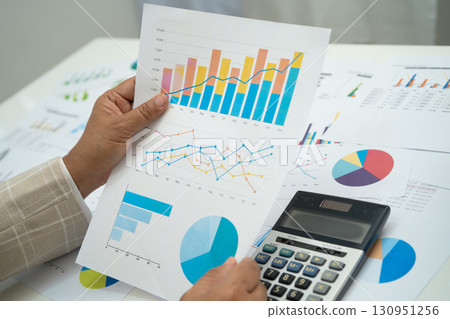 Asian business woman working with financial graph. 130951256