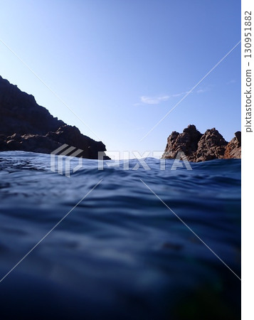 Sky and rocks seen from the water 130951882