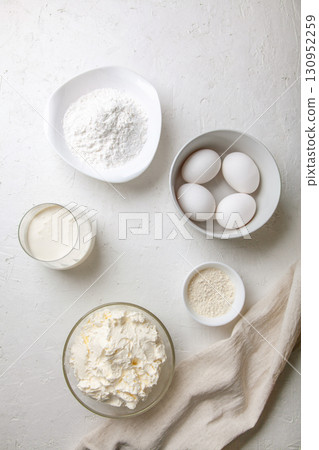 Ingredients for cooking Basque Spanish burnt Saint Sebastian cheesecake. Baking products - cream cheese, sugar, eggs, flour and cream on light background. Recipe step by step flatlay top view 130952259