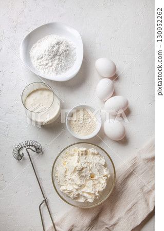 Ingredients for cooking Basque Spanish burnt Saint Sebastian cheesecake. Baking products - cream cheese, sugar, eggs, flour and cream on light background. Recipe step by step flatlay top view Ingredients for cooking Basque Spanish burnt Saint Sebastian cheesecake. Baking products - cream cheese, sugar, eggs, flour and cream on light background. Recipe step by step flatlay top view 130952262