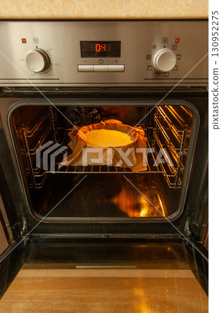 Cooking process homemade Basque burnt cheesecake. The form covered paper with the dough is in the oven and baked. Recipe step by step Cooking process homemade Basque burnt cheesecake. The form covered paper with the dough is in the oven and baked. Recipe step by step 130952275