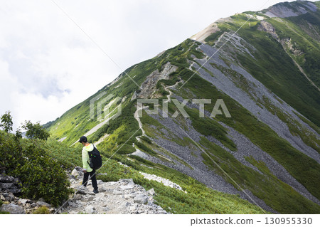 一名男子沿著北阿爾卑斯山脊行走 130955330