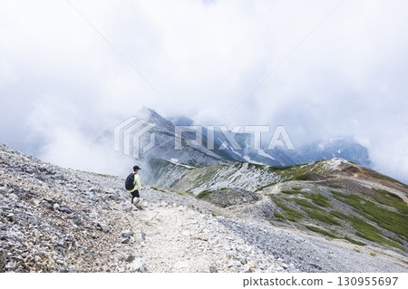 一名男子沿著北阿爾卑斯山脊行走 130955697