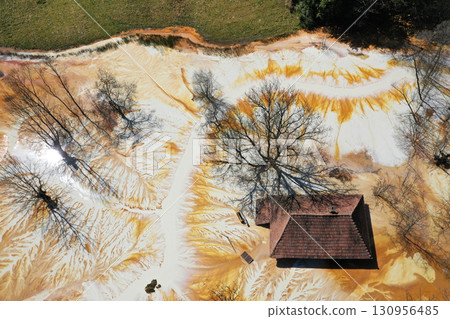 Aerial view of sinking village house in the middle of toxic mine decanting lake Aerial view of sinking village house in the middle of toxic mine decanting lake 130956485