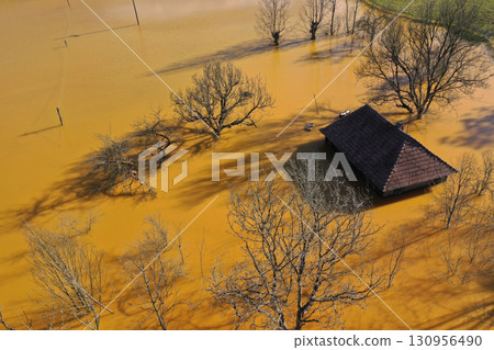 Aerial view of sinking village house in the middle of toxic mine decanting lake 130956490