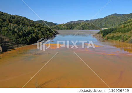Aerial view of surreal natural patterns of gold cyanide leaching flowing into decanting lake 130956769