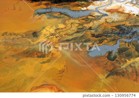 Aerial view of surreal natural patterns of gold cyanide leaching flowing into decanting lake 130956774