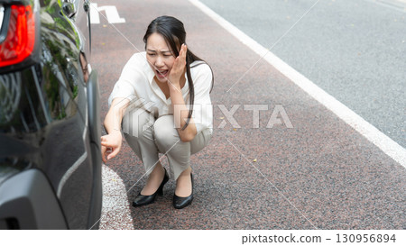Woman checking a car Woman checking a car 130956894
