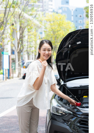 檢查汽車的女人豎起大拇指 130956916