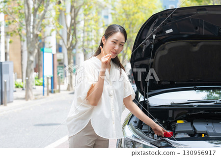 檢查汽車的女人指著 130956917