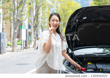 檢查汽車的女人指著 130956920