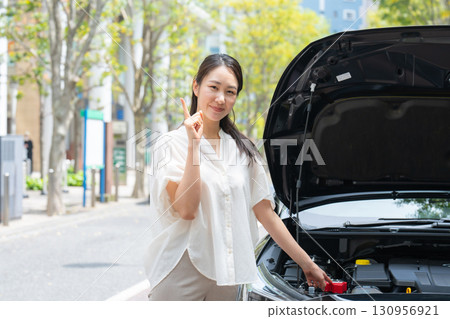 檢查汽車的女人指著 130956921