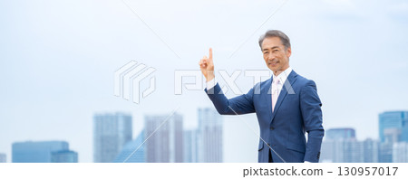 Businessman pointing at buildings Businessman pointing at buildings 130957017