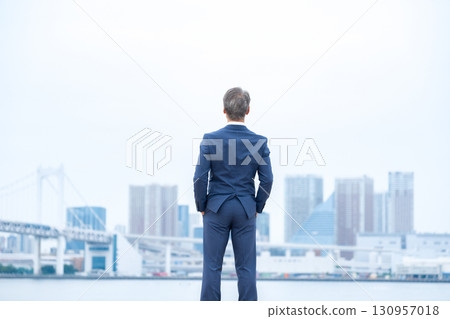Businessman, buildings, back view Businessman, buildings, back view 130957018