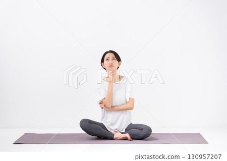 Woman doing yoga thinking 130957207
