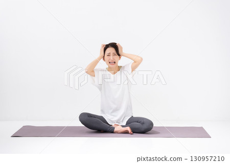 Woman doing yoga holding her head 130957210