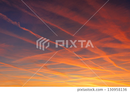 Scenic dramatic colorful sunset or sunrise sky landscape many aircraft jet contrail crossing. Natural beautiful dawn background wallpaper. Twilight time cloudscape. Europe aircraft traffic 130958136