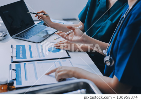 Medical team meeting analyzing blood test results in hospital laboratory. Doctors and scientists in lab coats are having a discussion about blood test result, holding test tubes and taking notes. Medical team meeting analyzing blood test results in hospital laboratory. Doctors and scientists in lab coats are having a discussion about blood test result, holding test tubes and taking notes. 130958374