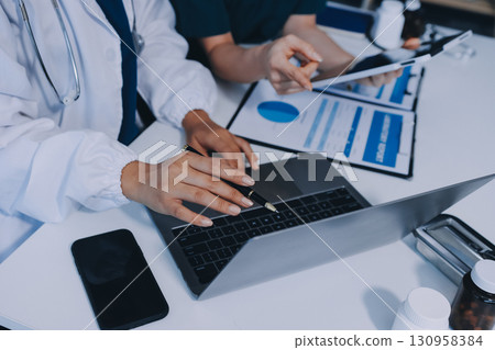 Medical team meeting analyzing blood test results in hospital laboratory. Doctors and scientists in lab coats are having a discussion about blood test result, holding test tubes and taking notes. Medical team meeting analyzing blood test results in hospital laboratory. Doctors and scientists in lab coats are having a discussion about blood test result, holding test tubes and taking notes. 130958384
