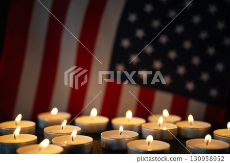 United States flag with candlelight, symbolizing tribute, respect, and national pride. Great background for Veterans Day, Memorial Day, and patriotic remembrance events. 130958952