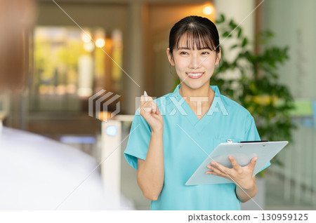 一位年輕的女醫生正在檢查病人 130959125