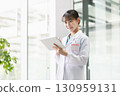 A young female doctor operating a tablet 130959131