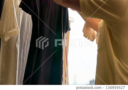 A series of photographs of a man taking in the laundry. A man doing housework. 130959327