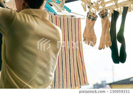 一組照片，一名男子正在洗衣服。一名男子正在做家事。 130959331