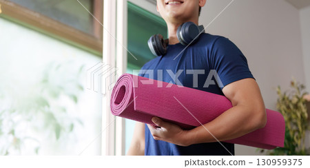 Home Workout. Individual with yoga mat and headphones ready for exercise. 130959375