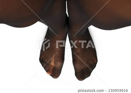 female legs in torn tights on white background, close-up, top view 130959916