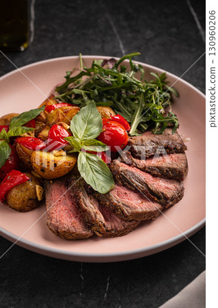Grilled steak slices with potato tomato arugula 130960206